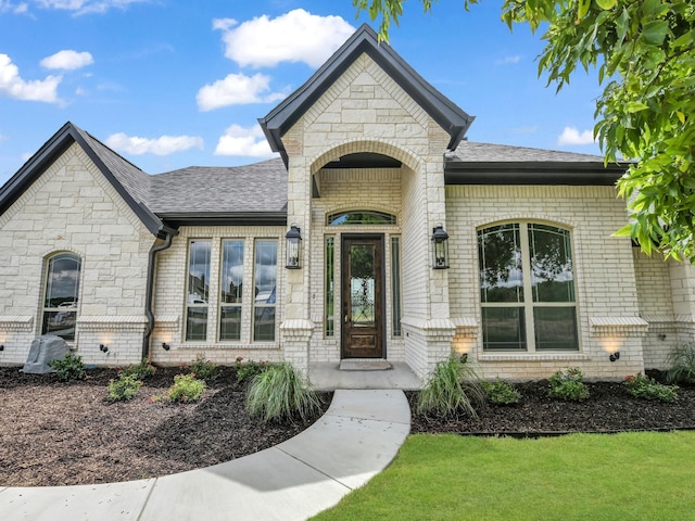 161 Altom Rd, Springtown, TX 76082 - doorway to property with brick siding, roof with shingles, stone siding, and a lawn