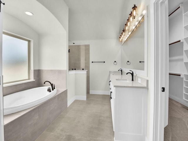 161 Altom Rd, Springtown, TX 76082 - full bathroom featuring walk in shower, a bath, double vanity, a spacious closet, and baseboards