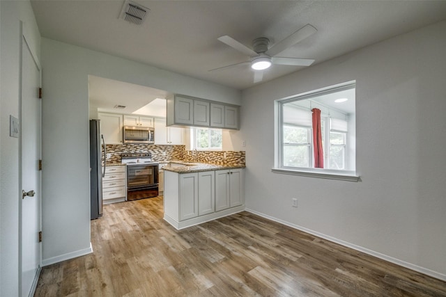 2315 Yale Dr, Arlington, TX 76015 - kitchen with appliances with stainless steel finishes, ceiling fan, light wood finished floors, and baseboards
