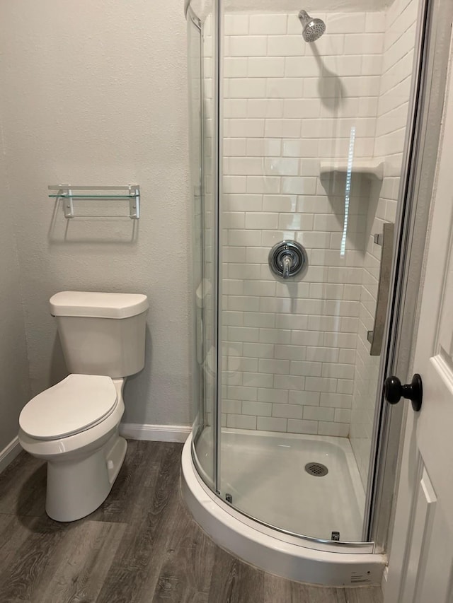 1605 Baltimore Dr, Richardson, TX 75081 - bathroom with wood finished floors, a stall shower, baseboards, and toilet