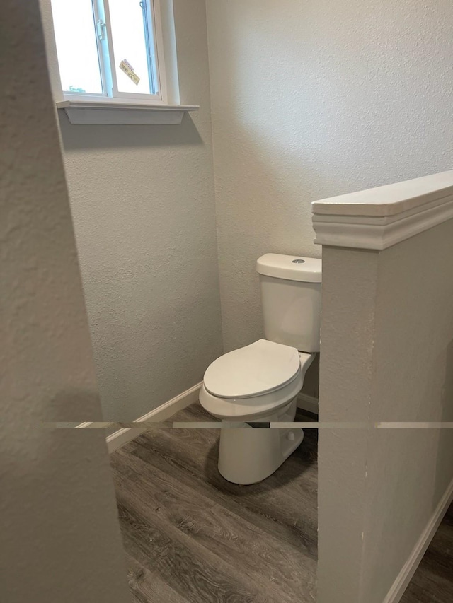 1605 Baltimore Dr, Richardson, TX 75081 - bathroom with wood finished floors, toilet, a textured wall, and baseboards