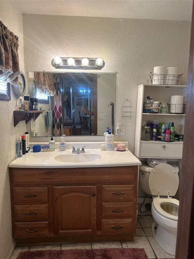 567 N Rice, Hamilton, TX 76531 - bathroom with a textured wall, vanity, toilet, and tile patterned flooring