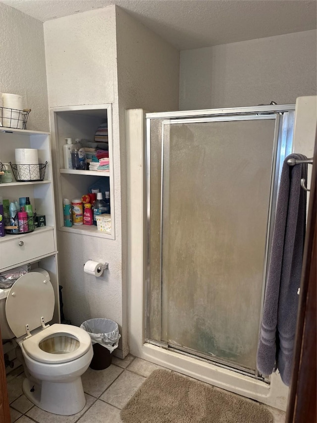 567 N Rice, Hamilton, TX 76531 - bathroom with a stall shower, a textured wall, tile patterned floors, and toilet