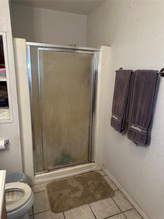 567 N Rice, Hamilton, TX 76531 - bathroom with a stall shower, toilet, tile patterned flooring, and baseboards