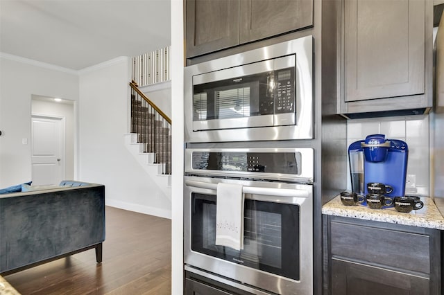 7216 Monet Ln, Grand Prairie, TX 75054 - kitchen featuring appliances with stainless steel finishes, crown molding, dark wood finished floors, dark brown cabinets, and baseboards