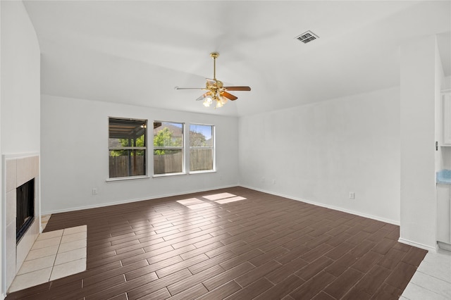 6745 Bear Hollow Ln, Watauga, TX 76137 - unfurnished living room featuring a ceiling fan, dark wood-style floors, a tiled fireplace, and baseboards