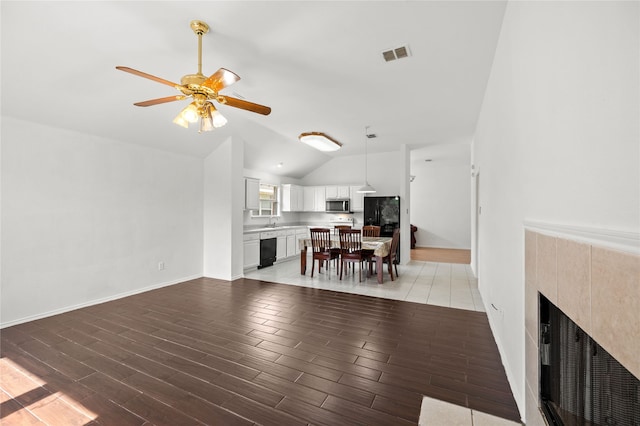 6745 Bear Hollow Ln, Watauga, TX 76137 - living room with lofted ceiling, a ceiling fan, a fireplace, light wood finished floors, and baseboards