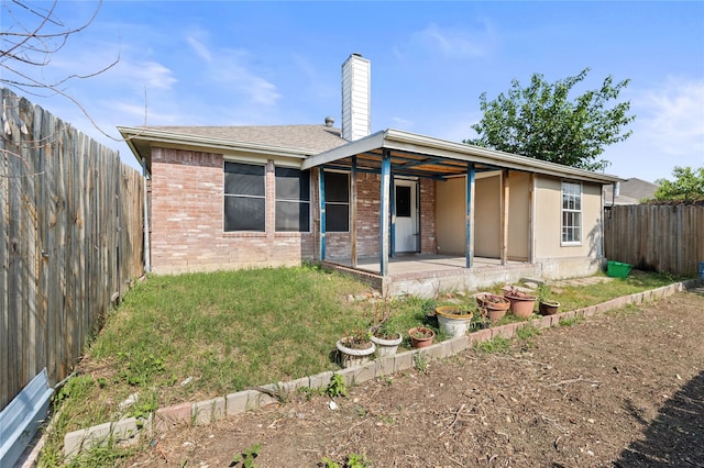 6745 Bear Hollow Ln, Watauga, TX 76137 - back of property with a patio area, brick siding, and a chimney