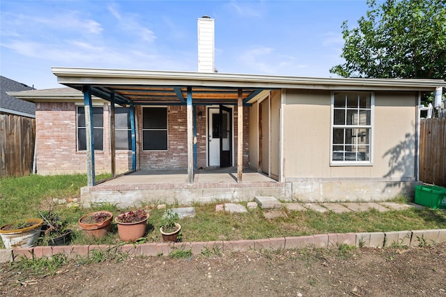 6745 Bear Hollow Ln, Watauga, TX 76137 - view of front of home featuring brick siding, a chimney, and a porch