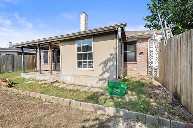6745 Bear Hollow Ln, Watauga, TX 76137 - back of house with a fenced backyard, a chimney, and a patio area