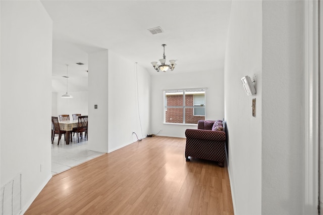 6745 Bear Hollow Ln, Watauga, TX 76137 - corridor featuring a chandelier, light wood-type flooring, and baseboards