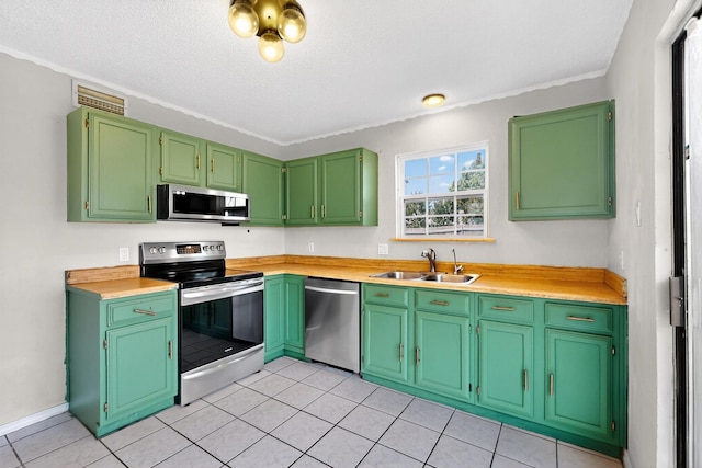 205 Callender Dr, Fort Worth, TX 76108 - kitchen with stainless steel appliances, a sink, light countertops, light tile patterned flooring, and a textured ceiling
