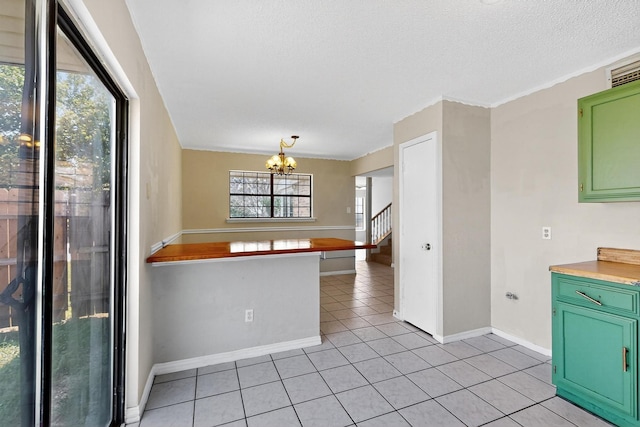205 Callender Dr, Fort Worth, TX 76108 - kitchen with green cabinetry, a chandelier, light tile patterned floors, baseboards, and a textured ceiling