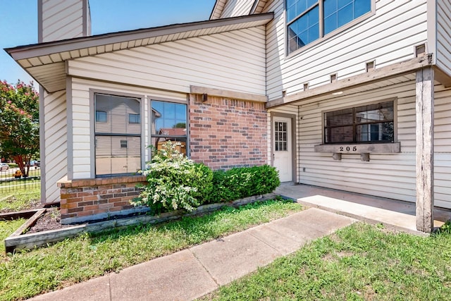 205 Callender Dr, Fort Worth, TX 76108 - view of exterior entry featuring brick siding and a chimney