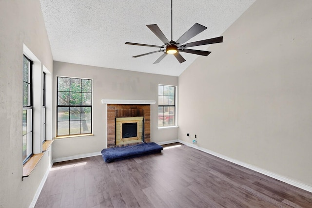 205 Callender Dr, Fort Worth, TX 76108 - unfurnished living room with healthy amount of natural light, a textured ceiling, wood finished floors, ceiling fan, and a brick fireplace