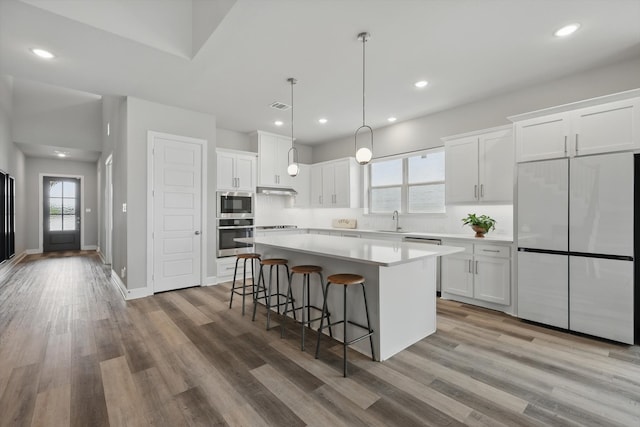 1302 20th St, Northlake, TX 76226 - kitchen featuring stainless steel appliances, a sink, a kitchen island, white cabinets, and light countertops