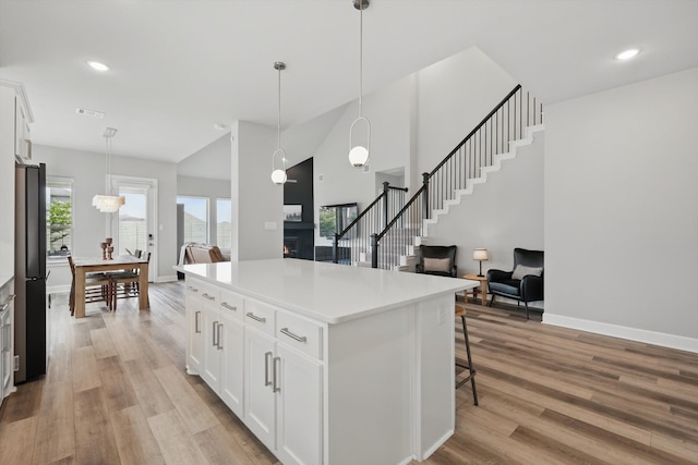 1302 20th St, Northlake, TX 76226 - kitchen with light wood-type flooring, white cabinetry, a breakfast bar area, pendant lighting, and recessed lighting