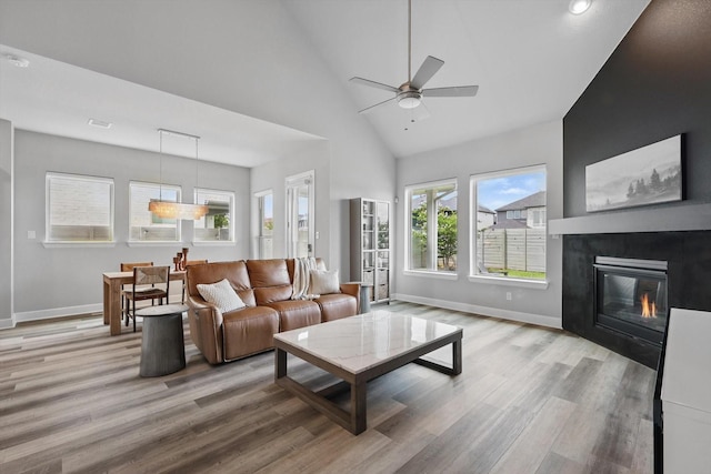 1302 20th St, Northlake, TX 76226 - living room with wood finished floors, baseboards, ceiling fan, a glass covered fireplace, and high vaulted ceiling