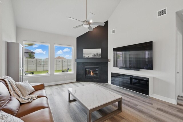 1302 20th St, Northlake, TX 76226 - living area with high vaulted ceiling, ceiling fan, a glass covered fireplace, baseboards, and wood finished floors