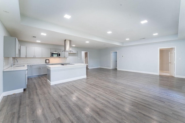 2835 Gladstone Dr, Dallas, TX 75211 - kitchen with stainless steel microwave, island exhaust hood, a sink, a tray ceiling, and recessed lighting