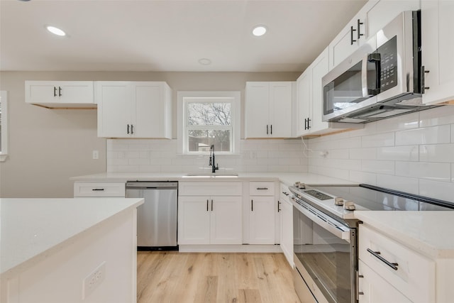 4955 Odessa Ave, Fort Worth, TX 76133 - kitchen with appliances with stainless steel finishes, a sink, light wood-style flooring, recessed lighting, and tasteful backsplash