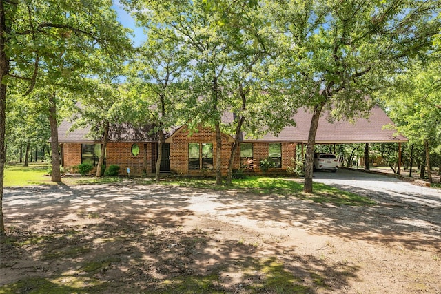 483 County Road 1591, Sunset, TX 76270 - view of front facade featuring dirt driveway, brick siding, and an attached carport