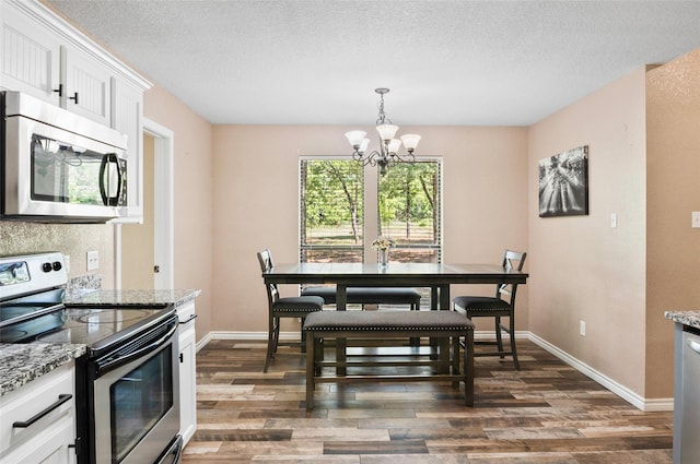 483 County Road 1591, Sunset, TX 76270 - dining space with a chandelier, dark wood finished floors, baseboards, and a textured ceiling