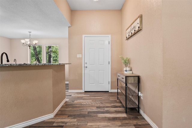 483 County Road 1591, Sunset, TX 76270 - foyer entrance with dark wood-type flooring, a chandelier, baseboards, and a textured wall