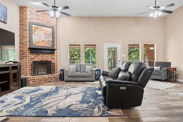 483 County Road 1591, Sunset, TX 76270 - living room featuring a ceiling fan, wood finished floors, a fireplace, plenty of natural light, and a towering ceiling