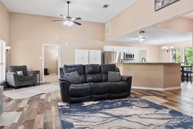 483 County Road 1591, Sunset, TX 76270 - living area with a chandelier, wood finished floors, a towering ceiling, a ceiling fan, and baseboards