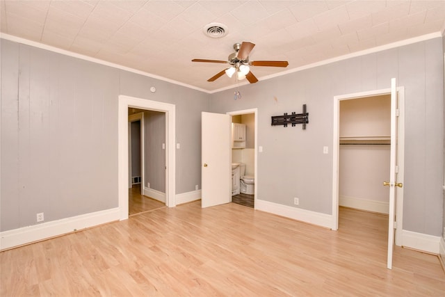 307 Smith St, Hillsboro, TX 76645 - unfurnished bedroom featuring crown molding, light wood finished floors, a spacious closet, ensuite bathroom, and a closet