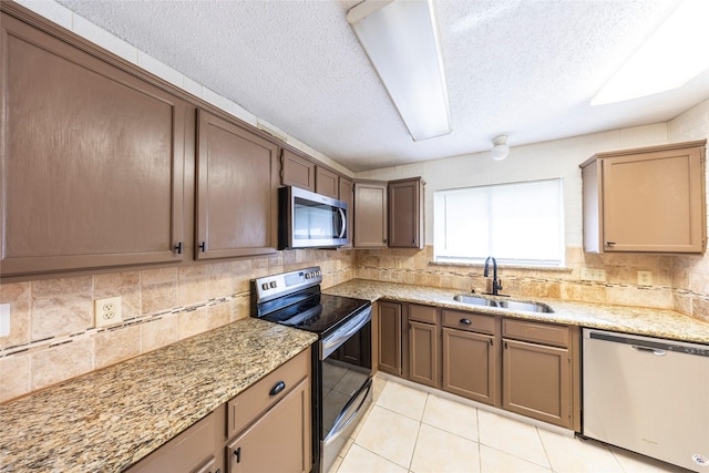 6900 Tudor Dr, Plano, TX 75023 - kitchen with stainless steel appliances, a sink, decorative backsplash, a textured ceiling, and light tile patterned floors