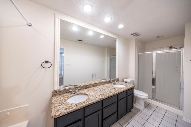 6900 Tudor Dr, Plano, TX 75023 - full bathroom featuring toilet, a shower stall, double vanity, tile patterned floors, and a textured ceiling