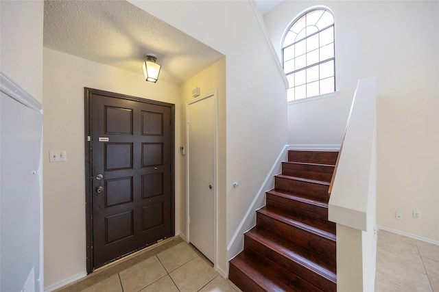 6900 Tudor Dr, Plano, TX 75023 - entrance foyer with light tile patterned floors, stairway, and baseboards