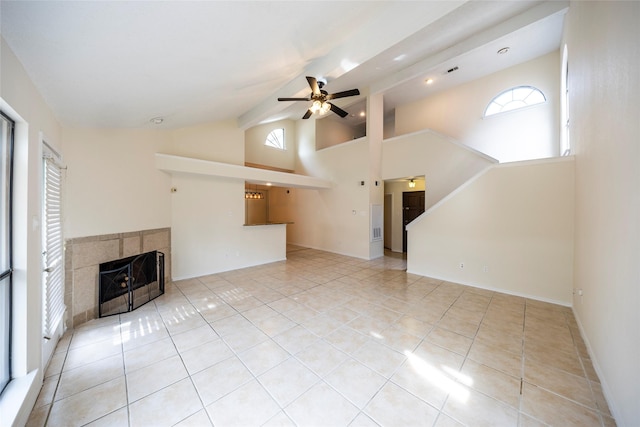6900 Tudor Dr, Plano, TX 75023 - unfurnished living room with ceiling fan, tile patterned floors, high vaulted ceiling, a tile fireplace, and baseboards