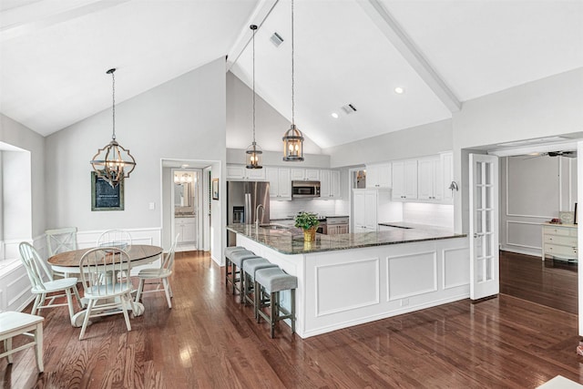 2203 Glascow Ct, Carrollton, TX 75007 - kitchen with appliances with stainless steel finishes, a sink, high vaulted ceiling, white cabinets, and dark stone countertops