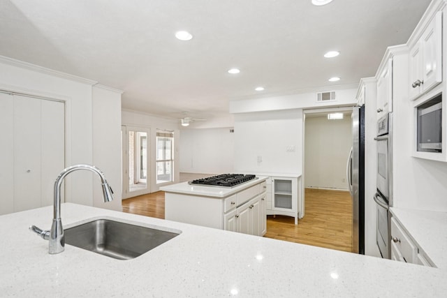 4016 Willow Ridge Dr, Dallas, TX 75244 - kitchen with a sink, appliances with stainless steel finishes, white cabinets, crown molding, and recessed lighting