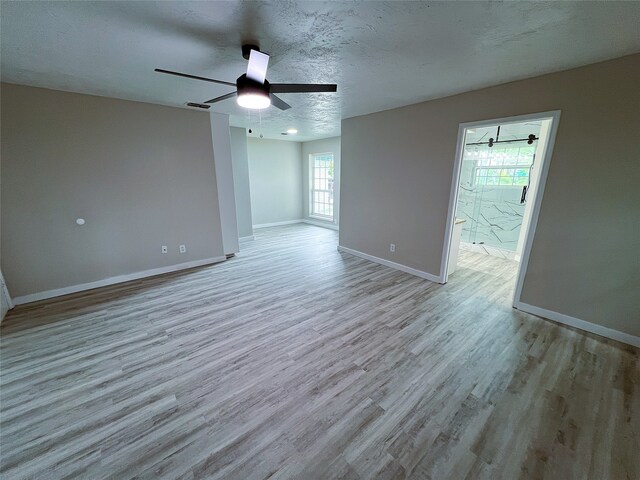 2946 Ridgewood Dr, Grapevine, TX 76051 - empty room with wood finished floors, baseboards, a ceiling fan, and a textured ceiling
