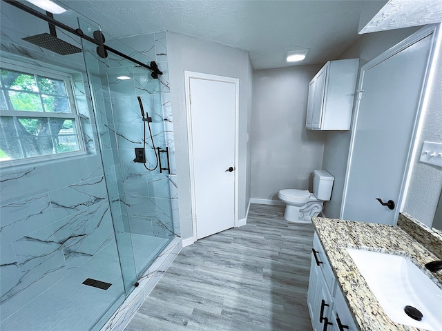 2946 Ridgewood Dr, Grapevine, TX 76051 - bathroom with a marble finish shower, vanity, toilet, wood finished floors, and baseboards