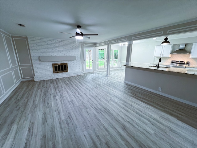 2946 Ridgewood Dr, Grapevine, TX 76051 - unfurnished living room with a sink, a ceiling fan, a brick fireplace, and wood finished floors