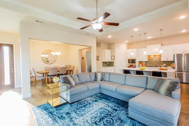 7721 Haddington, The Colony, TX 75056 - living room featuring a chandelier, ornamental molding, light wood finished floors, a ceiling fan, and recessed lighting