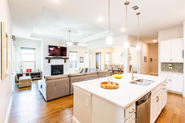 7721 Haddington, The Colony, TX 75056 - kitchen featuring a sink, stainless steel dishwasher, light wood-type flooring, and a raised ceiling