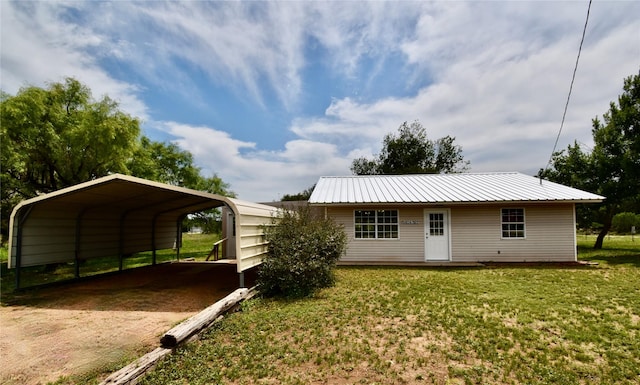 5604 5th St, Rochelle, TX 76872 - rear view of house featuring a carport, driveway, a yard, and metal roof