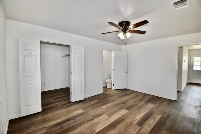 5604 5th St, Rochelle, TX 76872 - unfurnished bedroom featuring dark wood finished floors, connected bathroom, baseboards, and a walk in closet