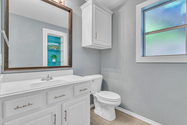 4001 Elmhill Dr, Plano, TX 75024 - half bath featuring toilet, vanity, baseboards, and wood finished floors
