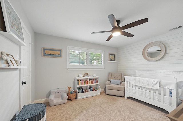 16905 Colegrove Dr, Dallas, TX 75248 - carpeted bedroom with a nursery area, ceiling fan, wood walls, and baseboards