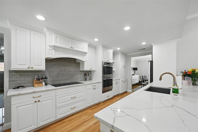 16905 Colegrove Dr, Dallas, TX 75248 - kitchen with a sink, black electric cooktop, light wood-style floors, crown molding, and backsplash