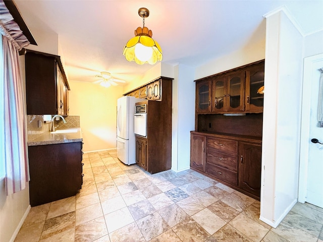 1210 Carroll Dr, Garland, TX 75041 - kitchen with white appliances, a sink, decorative backsplash, a ceiling fan, and baseboards