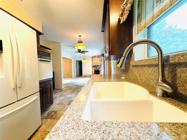 1210 Carroll Dr, Garland, TX 75041 - kitchen featuring white appliances, a sink, a ceiling fan, tasteful backsplash, and hanging light fixtures
