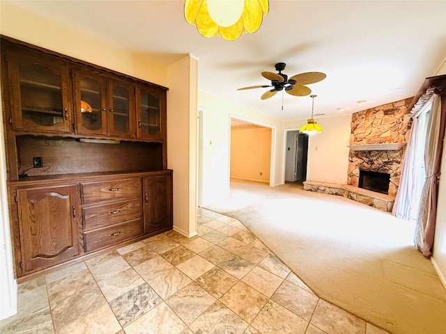 1210 Carroll Dr, Garland, TX 75041 - unfurnished living room featuring light colored carpet, a stone fireplace, ceiling fan, and baseboards